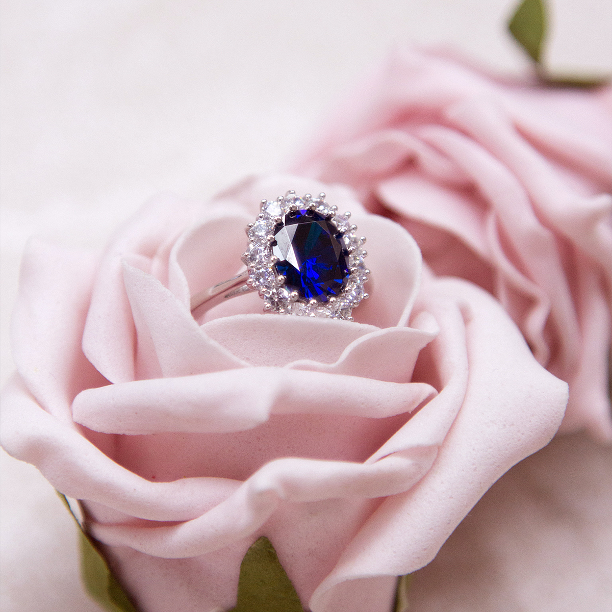 Sterling Silver Oval Shaped Blue Cubic Zirconia Cluster Ring Placed in the Centre of A Rose