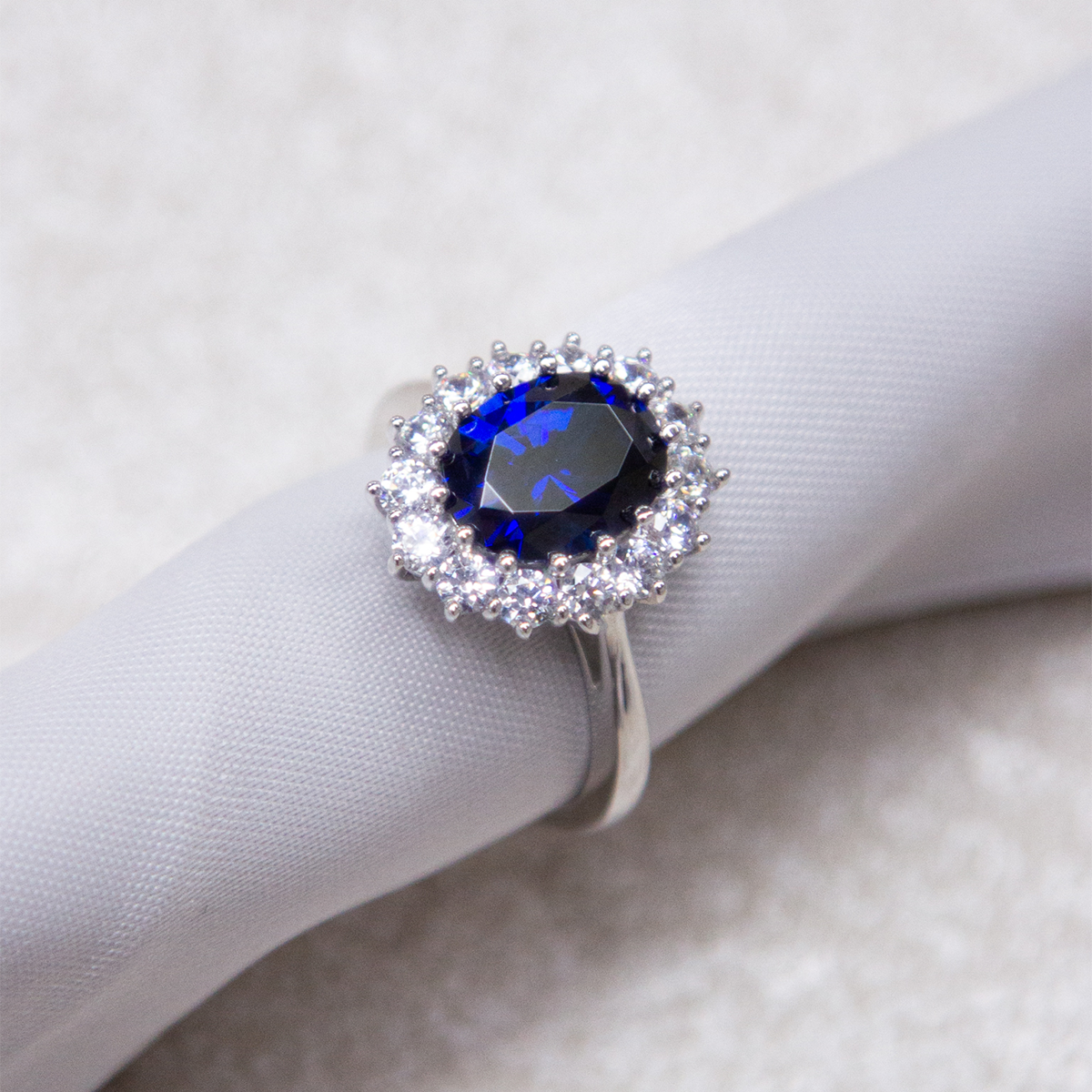 Sterling Silver Oval Shaped Blue Cubic Zirconia Cluster Ring on Fabric