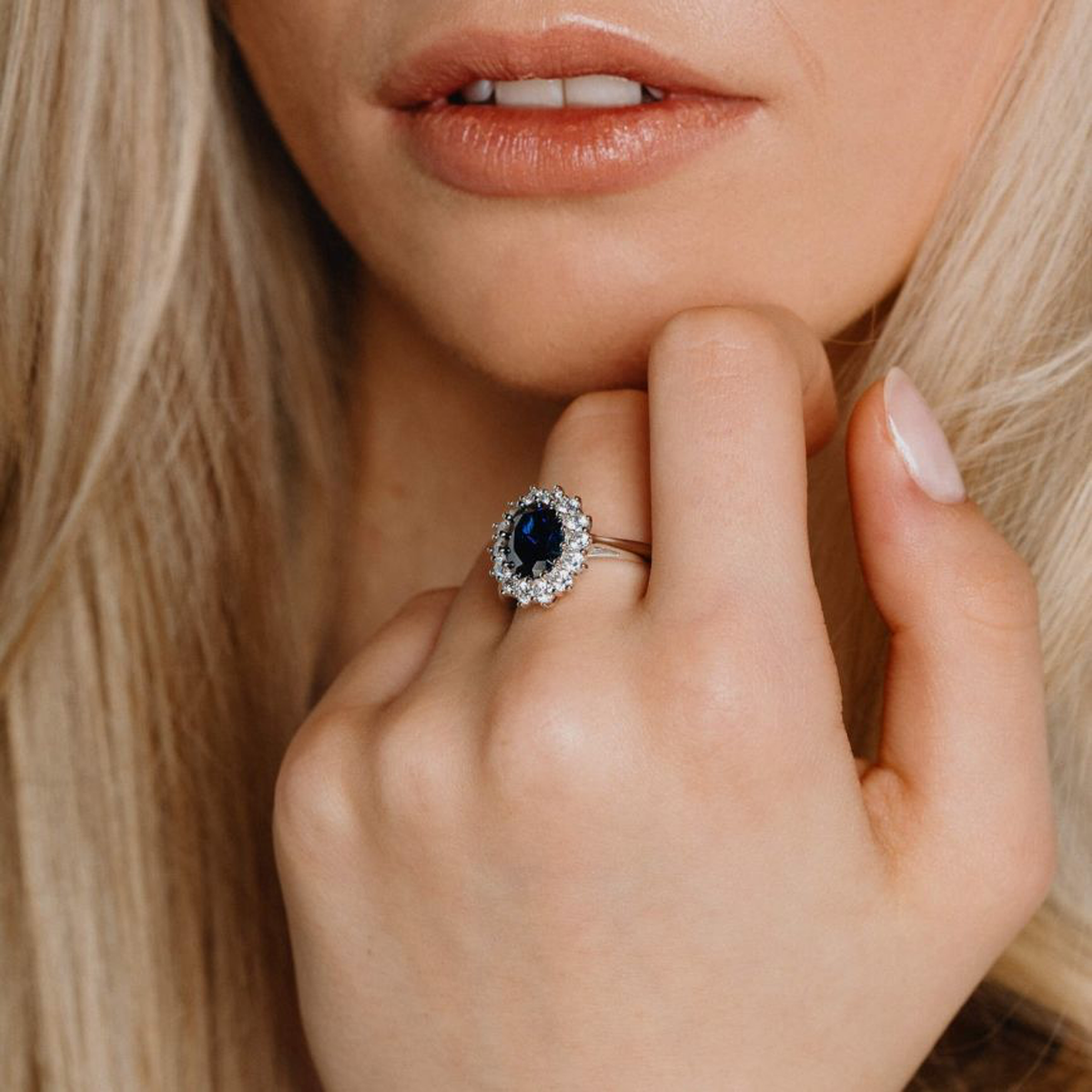 Model wears Sterling Silver Oval Shaped Blue Cubic Zirconia Cluster Ring